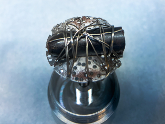 A small sample of iron-iodide held by Bai (above) is mounted and prepared for neutron scattering experiments which were used to measure the material’s fundamental magnetic excitations. (Credit: ORNL/Genevieve Martin)