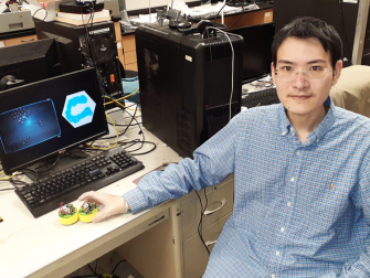 Shengkai Li, a graduate student in physics at Georgia Tech, with two BOBbots (Credit: Shengkai Li)
