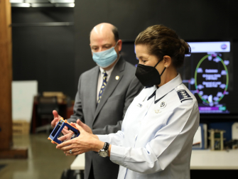 Lt. General Nina Armagno holds cubesat designed by the Space Systems Design Lab’s lab, led by professor Glenn Lightsey.