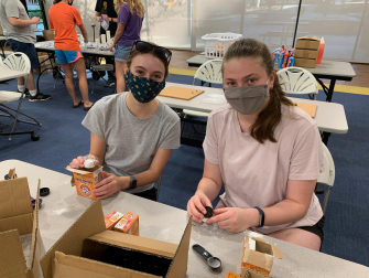 Little Einstein Organization volunteers Paige Holland (left) and Grace May prepare at-home science kits for Atlanta K-5 students. (Photo: Olivia Gravina)